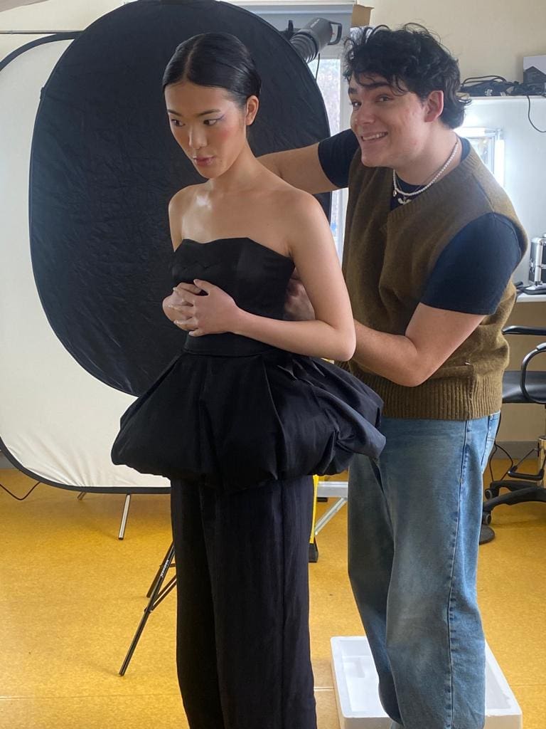 Student applying makeup to a model
